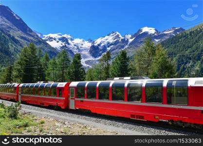 Swiss mountain train Bernina Express crossed Alps with glaciers in the backgroundin the summer