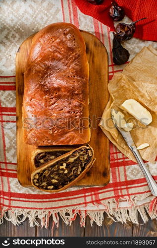 Swiss pear bread - Birnbrot. Local baked goods filled with dried pears, nuts and fruits. Top view of freshly baked pear bread sliced into slices, next to butter. Festive breakfast