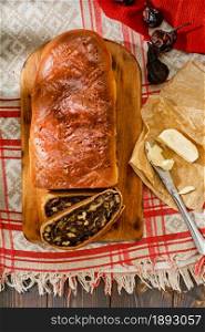 Swiss pear bread - Birnbrot. Local baked goods filled with dried pears, nuts and fruits. Top view of freshly baked pear bread sliced into slices, next to butter. Festive breakfast