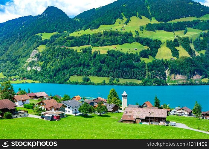 Swiss village Lungern with its traditional houses and old church tower Alter Kirchturm along the lake Lungerersee, canton of Obwalden, Switzerland. Swiss village Lungern, Switzerland