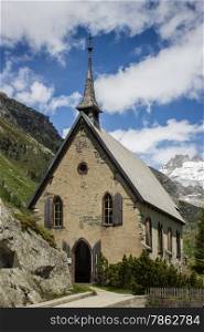 Switzerland, church among alpine mountains