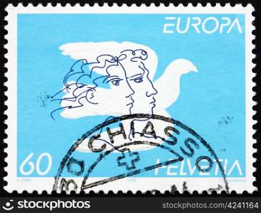 SWITZERLAND - CIRCA 1995: a stamp printed in the Switzerland shows Dove and faces, Peace and Freedom, circa 1995