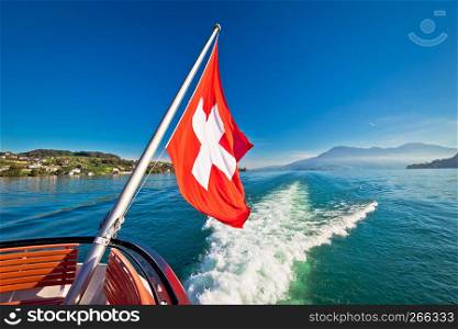 Switzerland flag on boat flowing Luzern lake, scenic landscape of Switzerland