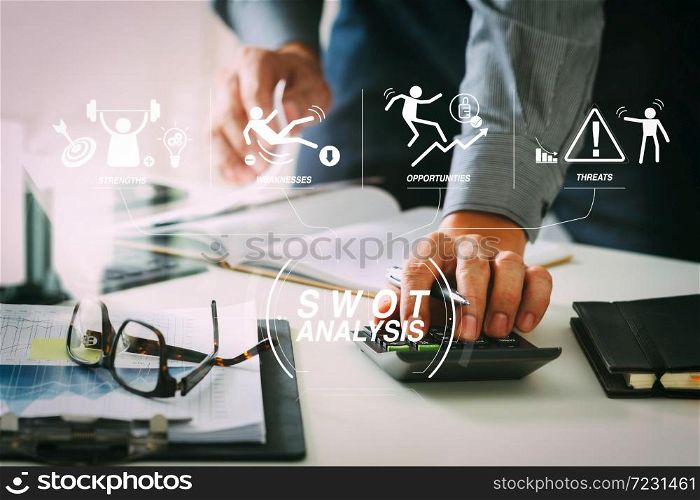 SWOT Analysis virtual diagram with Strengths, weaknesses, threats and opportunities of company.businessman hand working with finances about cost and calculator and latop with mobile phone on withe desk.