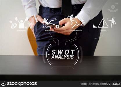SWOT Analysis virtual diagram with Strengths, weaknesses, threats and opportunities of company.businessman working with smart phone on wooden desk in modern office