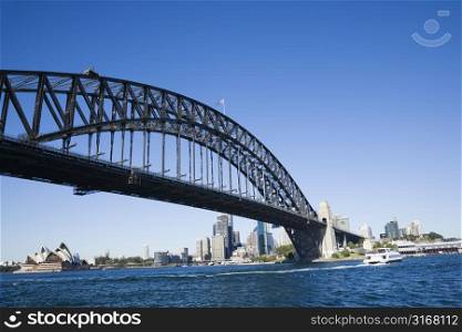 Sydney Harbour Bridge with view of downtown buildings and Sydney Opera House in Australia.