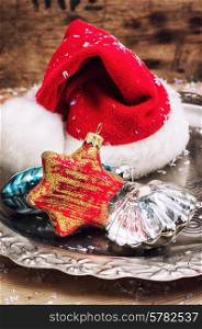 symbol of the Christmas hat on a metal tray with a glass of Soviet toys