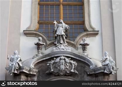 Symbolic figures of faith, hope and love above the main gate of Baroque, 18th century Saint Anne Church (Hungarian: Szent Anna templom) in Budapest, Hungary.