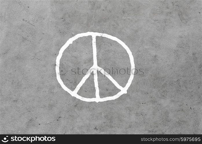 symbolic, pacifism and hippie concept - peace sign drawing on gray concrete wall