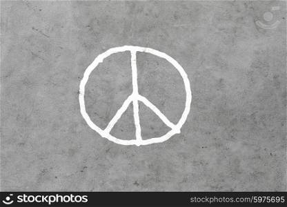 symbolic, pacifism and hippie concept - peace sign drawing on gray concrete wall