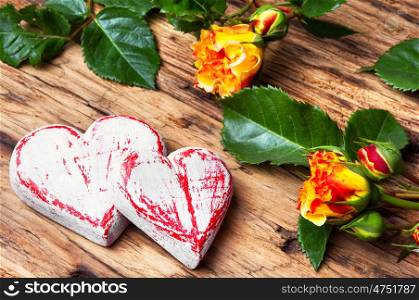 Symbolic wooden heart and flowers. Celebratory concept with symbolic hearts and a rose