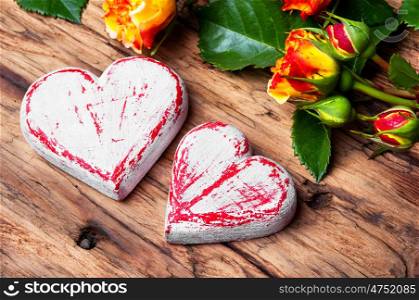 Symbolic wooden heart and flowers. Celebratory concept with symbolic hearts and a rose.Love concept.