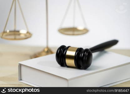 Symbolizing justice and legal authority, golden balanced scale and gavel on desk with law book in lawyer office background, reflecting concept of equality and fair judgment. equility. Golden balanced scale and gavel on desk with book in law office. equility