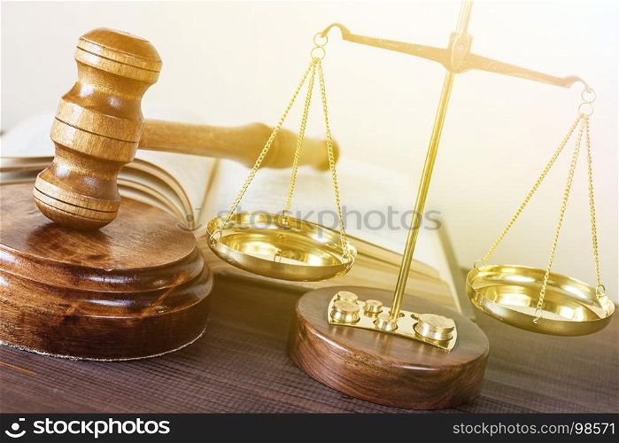 Symbols of law: wood gavel, soundblock, scales and opened volumetric old book