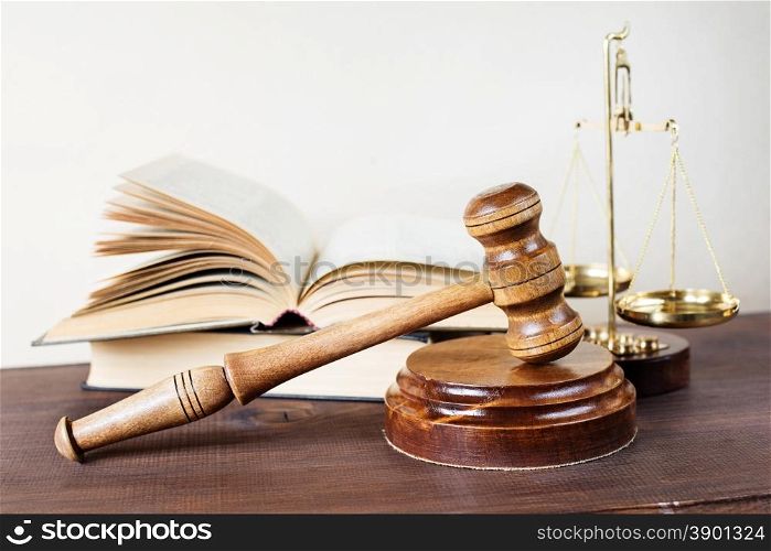 Symbols of law: wood gavel, soundblock, scales and opened volumetric old books