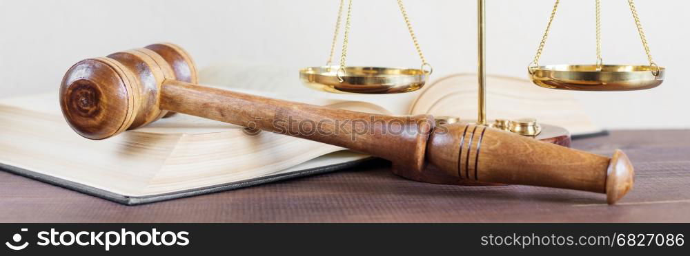 Symbols of law: wood gavel, soundblock, scales and opened volumetric old books