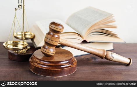 Symbols of law: wood gavel, soundblock, scales and opened volumetric old books