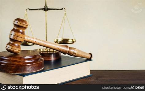 Symbols of law: wood gavel, soundblock, scales and thick old book