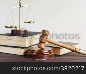 Symbols of law: wood gavel, soundblock, scales and three thick old books