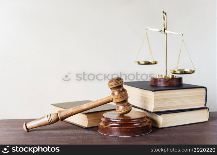 Symbols of law: wood gavel, soundblock, scales and three thick old books