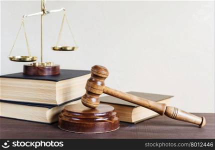 Symbols of law: wood gavel, soundblock, scales and three thick old books