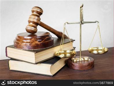 Symbols of law: wood gavel, soundblock, scales and two thick old books