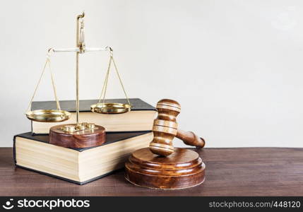 Symbols of law: wood gavel, soundblock, scales and two thick old books