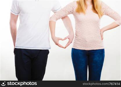 Symbols of love. Couple showing their connection and feelings by holding their hands strongly in shape of heart. Body language as expression of mind state.. Couple holding their hands.