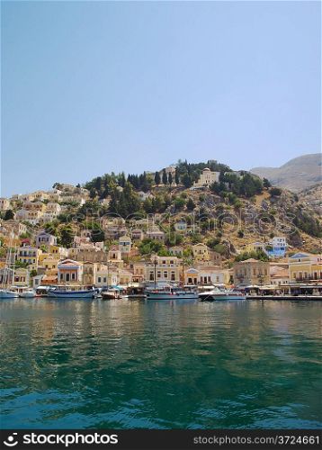 Symi town waterfront with moored motor boats and yachts, Greece.