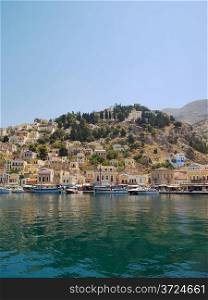 Symi town waterfront with moored motor boats and yachts, Greece.
