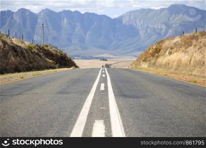 Symmetry of road with median strip in front of mountains in South Africa