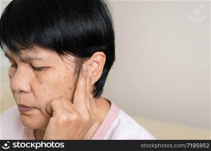 symptom of hearing loss of old woman. old woman couch with fingers near ear. healthcare problem of senior concept
