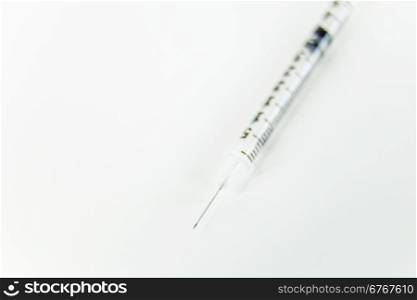 Syring with needle on white table with copy space