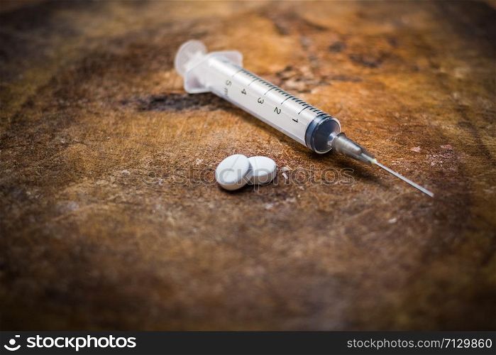 Syringe and heroin on wooden background with shadow edge. Drug addiction