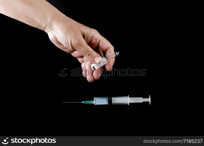 Syringe and pharmaceutical vial in human hands