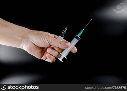 Syringe and pharmaceutical vial in human hands