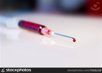 Syringe needle with blood drop macro view. Syringe needle with blood macro view