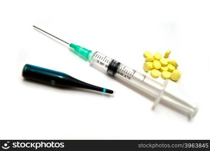 Syringe, tablets and ampoule on white background