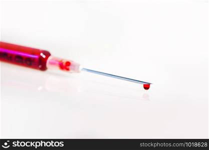 Syringe with blood closeup on white background. Syringe with blood on white background