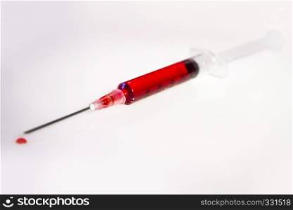 Syringe with blood closeup on white background. Syringe with blood on white background