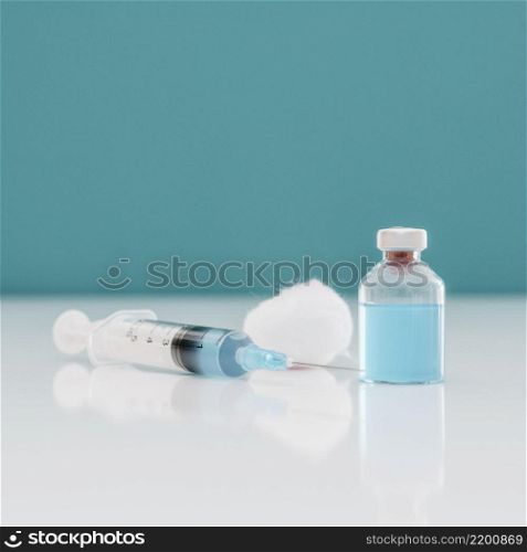 syringe with cotton vaccine bottle table