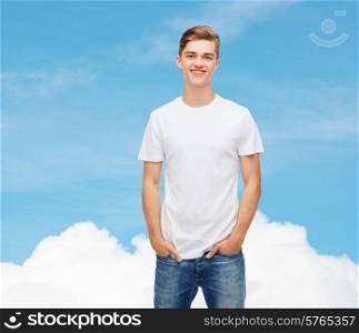 t-shirt design, advertising, dream and people concept - smiling young man in blank white t-shirt over blue sky background