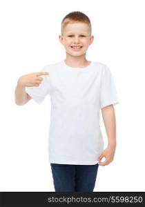 t-shirt design and advertisement concept - smiling little boy in blank white t-shirt pointing at herself