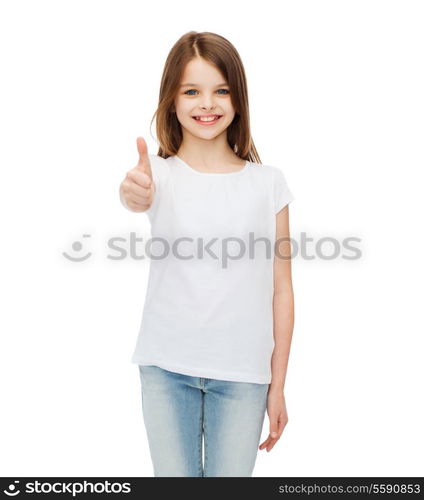 t-shirt design and happy people concept - smiling little girl in blank white t-shirt showing thumbs up