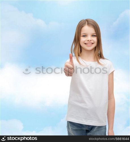 t-shirt design and happy people concept - smiling little girl in blank white t-shirt showing thumbs up
