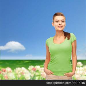 t-shirt design and people concept - smiling young woman in blank green t-shirt