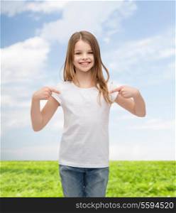 t-shirt design concept - smiling little girl in blank white t-shirt pointing at herself