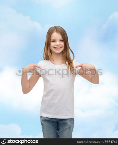 t-shirt design concept - smiling little girl in blank white t-shirt pointing at herself