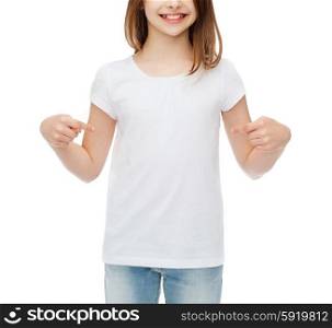t-shirt design concept - smiling little girl in blank white t-shirt pointing at herself. smiling little girl in blank white t-shirt