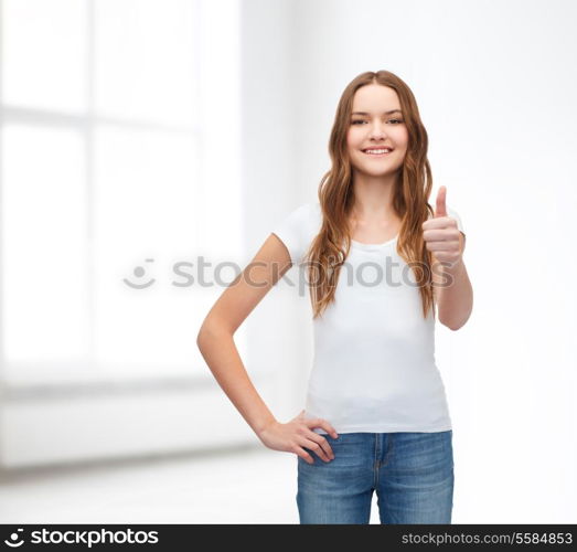 t-shirt design concept - smiling teenager in blank white t-shirt showing thumbs up